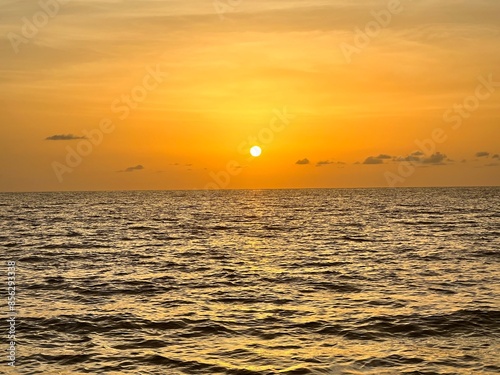 Golden sun melts into waves
