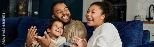 A loving African American family spending quality time together on a blue couch.