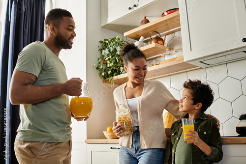 Φωτογραφία African American man, woman, child happily standing in kitchen.