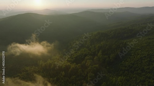 Fly over clouds during summer sunset in mountains  photo