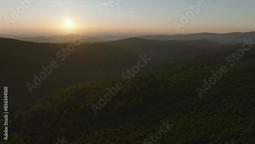 Summer sunset in the tree-covered mountains photo