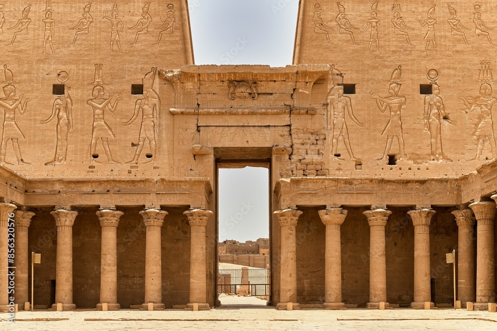 Fototapeta premium Egyptian temple with detailed carvings and columns under a clear sky.