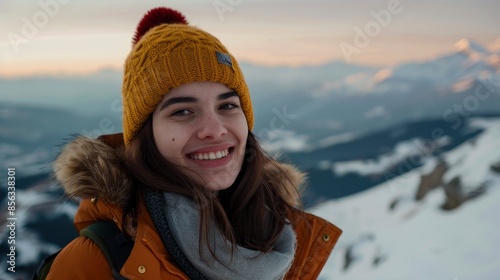 Young Woman At The Top Of A Snowy Mountain, Smiling And Happy In The Cold Weather