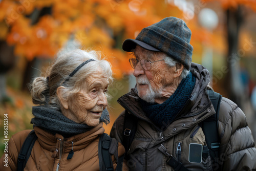 Elderly couple walking outdoors in autumn, enjoying conversation. © Мария Фадеева