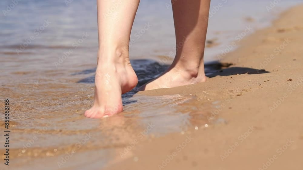 Bare female feet on the beach. Walk near the river in summer. Close-up of human feet standing in the sand near the water. Beach. Relax on the river in summer. A woman wets her feet in river water Bare female feet on the beach. Walk near the river in summer. Close-up of human feet standing in the sand near the water. Beach. Relax on the river in summer. A woman wets her feet in river water