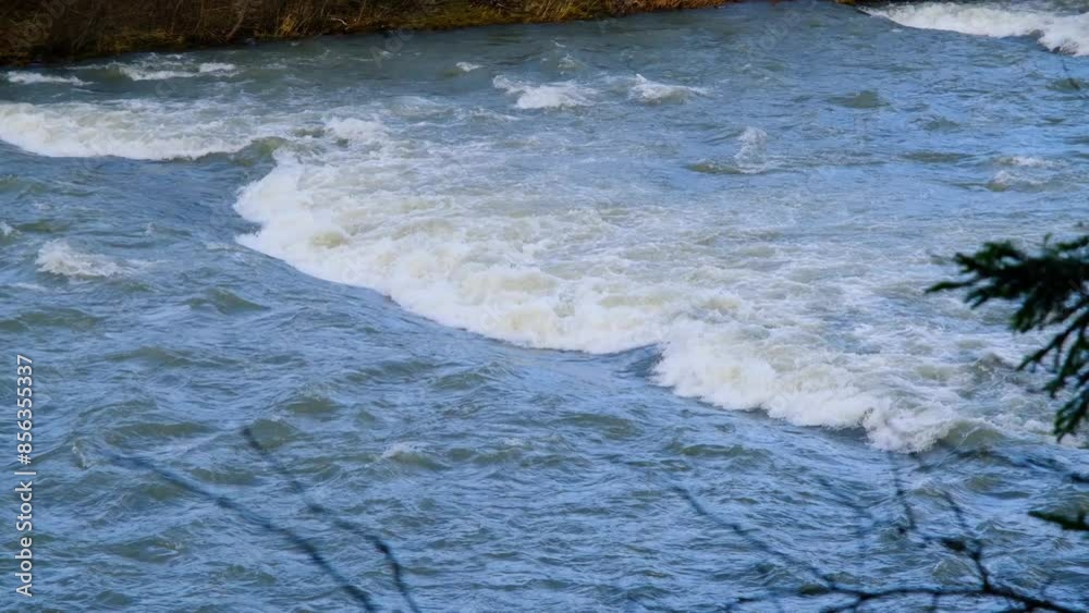 Raging mountain river. Full mountain river. The water is seething on the river rapids. mountain river