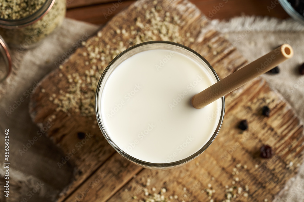Vegan hemp seed milk in a glass with an ecological bamboo straw, top view Vegan hemp seed milk in a glass with an ecological bamboo straw, top view