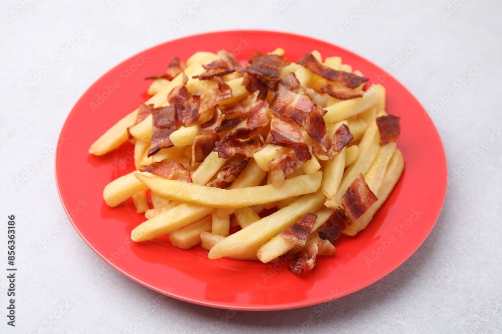 Delicious French fries with slices of bacon on light background, closeup Delicious French fries with slices of bacon on light background, closeup