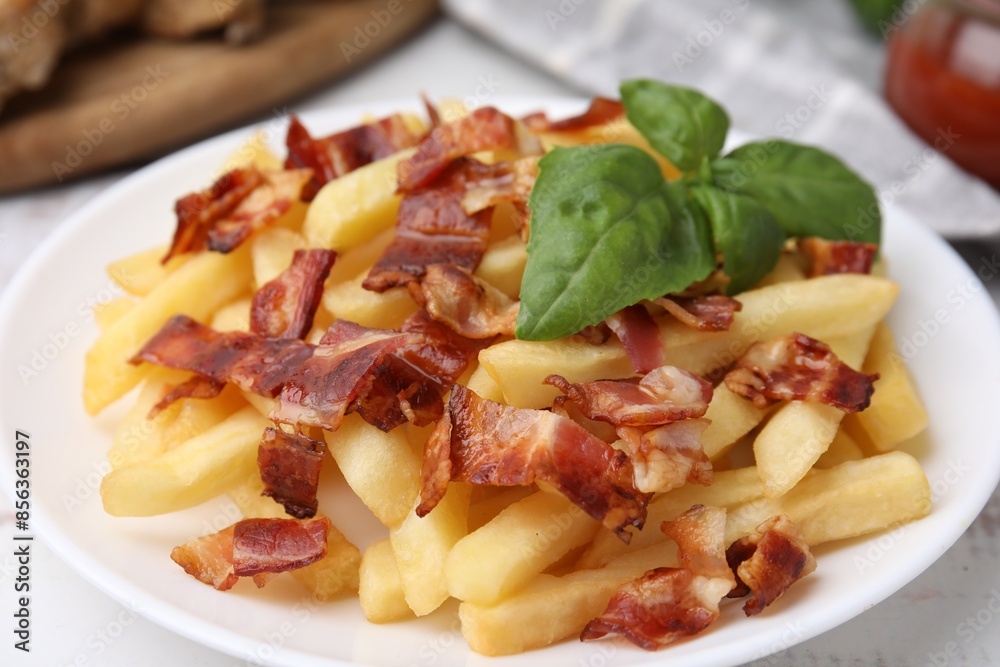 Delicious French fries with slices of bacon and basil on table, closeup Delicious French fries with slices of bacon and basil on table, closeup