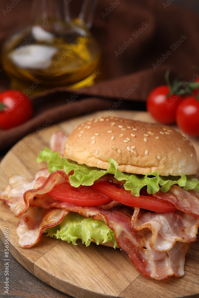 Delicious burger with bacon, tomato and lettuce on table Delicious burger with bacon, tomato and lettuce on table