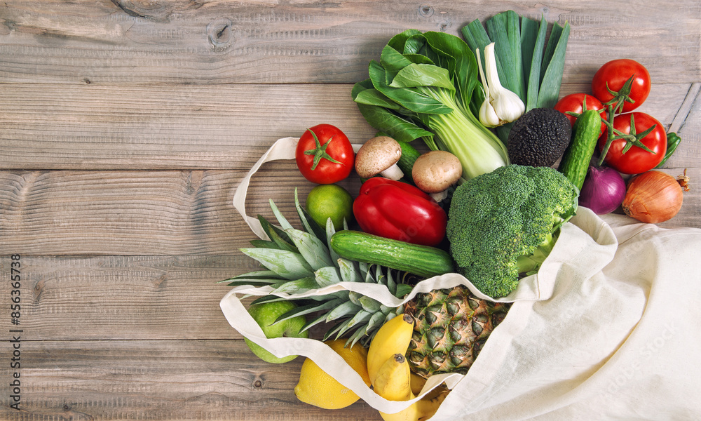 Healthy food. Fresh vegetables fruits in cotton bag. Tomato, cucumber, broccoli, pineapple, avocado, banane, salad Healthy food. Fresh vegetables fruits in cotton bag. Tomato, cucumber, broccoli, pineapple, avocado, banane, salad