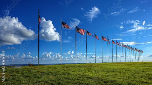 A row of American flags flying in the breeze against a bright blue sky with scattered clouds.Patriotic events, national holidays, educational materials. photo