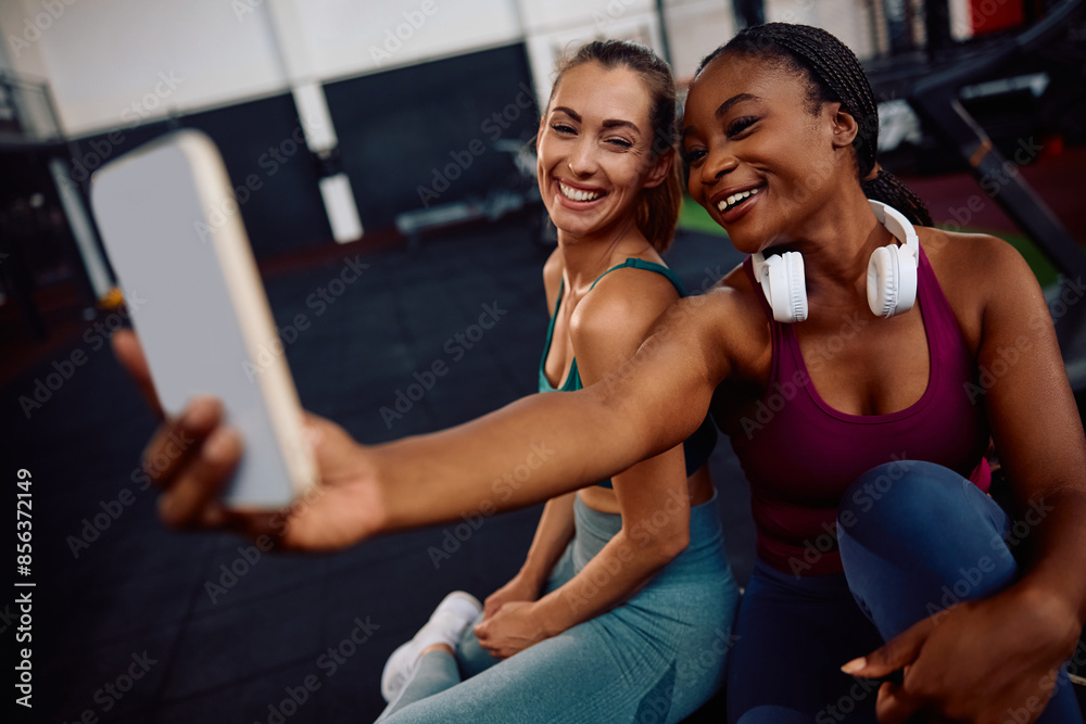 Happy athletic friends taking selfie while working out in gym. Happy athletic friends taking selfie while working out in gym.