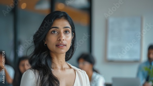 Young Indian woman leads diverse team in office meeting. Free Download Young Indian woman leads diverse team in office meeting. - GFXLoad