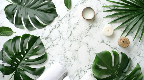 Spa and massage treatments on white  marble background monstera leaves. Flat lay. Top view