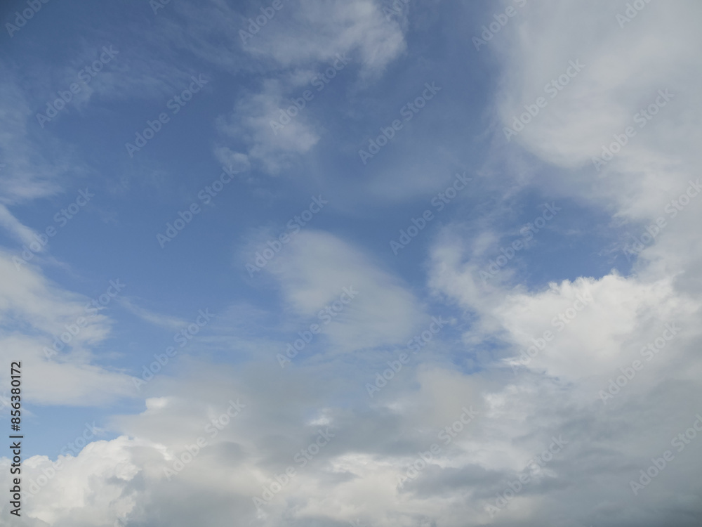The sky is blue with a few clouds scattered throughout. The clouds are white and fluffy, giving the sky a peaceful and serene appearance The sky is blue with a few clouds scattered throughout. The clouds are white and fluffy, giving the sky a peaceful and serene appearance