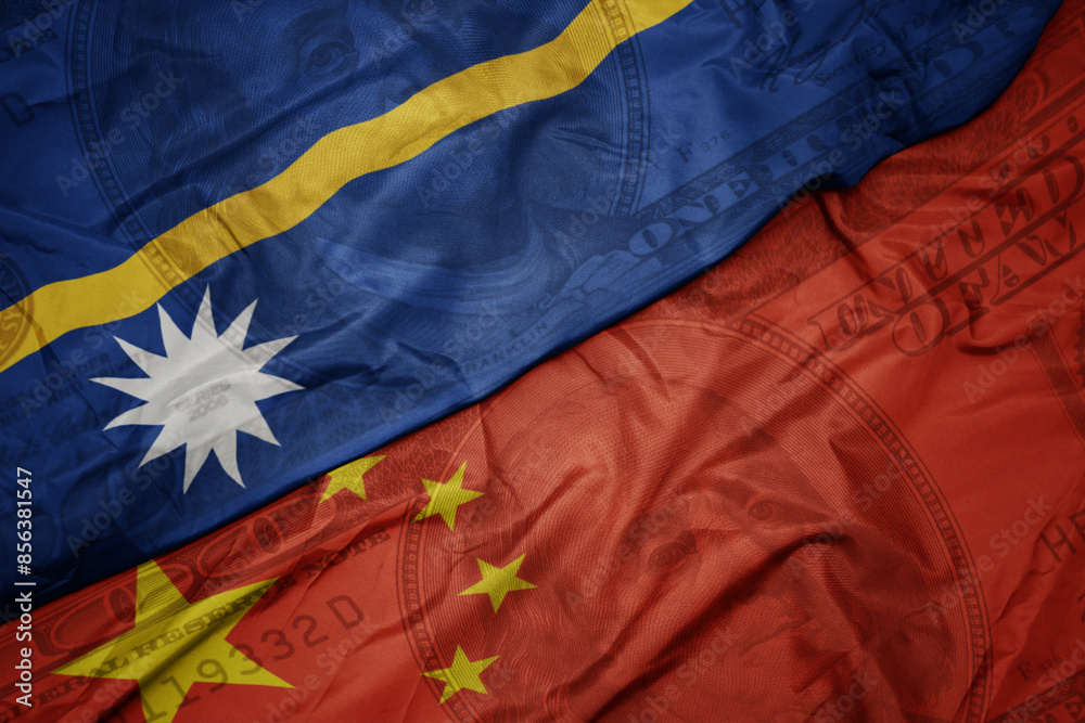 waving colorful flag of Nauru and national flag of china on the dollar money background. finance concept. waving colorful flag of Nauru and national flag of china on the dollar money background. finance concept.