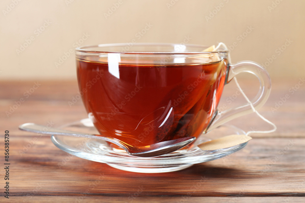 Brewing aromatic tea. Cup with teabag and spoon on wooden table Brewing aromatic tea. Cup with teabag and spoon on wooden table