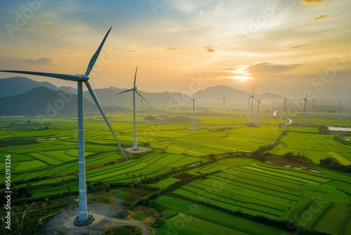In this picture, there is a landscape with a turbine generating green energy electricity. A windmill produces electricity on a rice field at Phan Rang, Ninh Thuan, Vietnam. The concept is clean photo