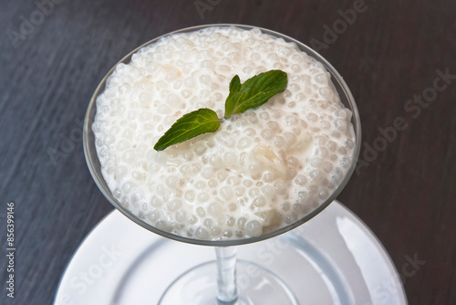 Tapioca sweet, tapioca pearl and mint dessert in a glass on a wooden table, sago seed pudding photo