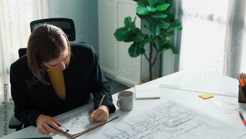 Top view of smart civil engineer drawing and measuring blueprint by using ruler. Aerial view of architect scatch building project plan at meeting table with equipment and safety helmet. Alimentation. photo