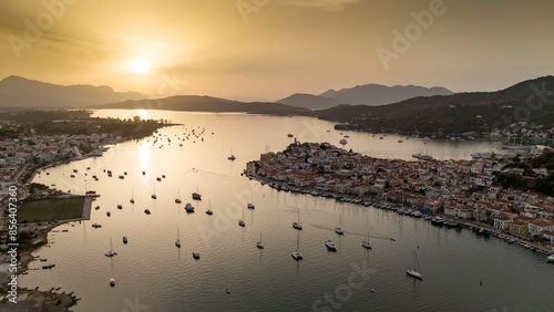 Aerial panorama of the city and harbor of Poros island in the Saronic Gulf, Greece, during a colorful summer sunset