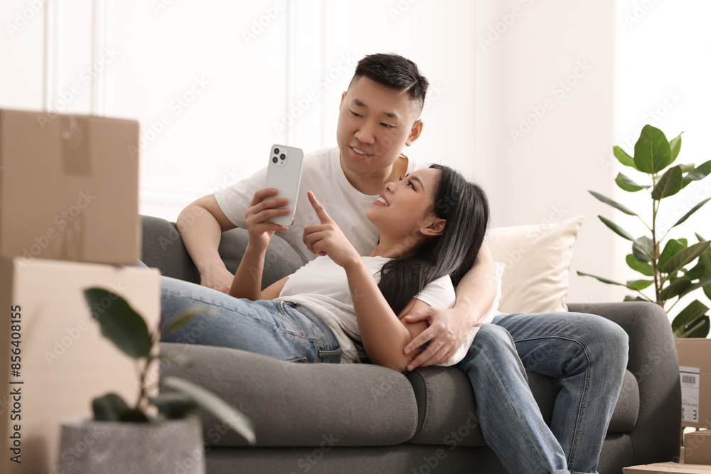 Happy couple with smartphone in their new apartment Happy couple with smartphone in their new apartment