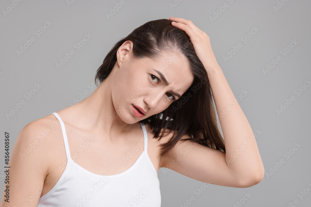 Sad woman with hair loss problem on grey background Sad woman with hair loss problem on grey background