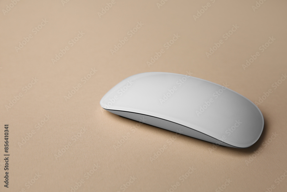 One wireless mouse on beige background, closeup. Space for text One wireless mouse on beige background, closeup. Space for text
