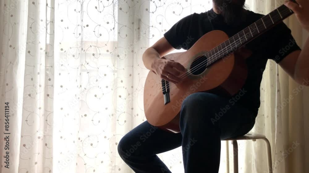 Chico tocando música con una guitarra clásica o española