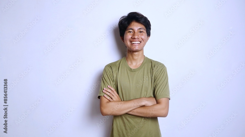 Handsome young Asian man smiling with crossed arms gesture Handsome young Asian man smiling with crossed arms gesture