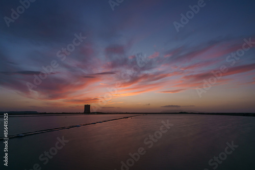 Vibrant sky during evening twilight after sunset at nature reserve Saline di Trapani with salt fields and Torre Nubia, Contrada Nubia, Sicily, Italy photo