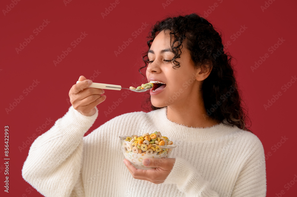 Young woman eating cereal rings on color background Young woman eating cereal rings on color background