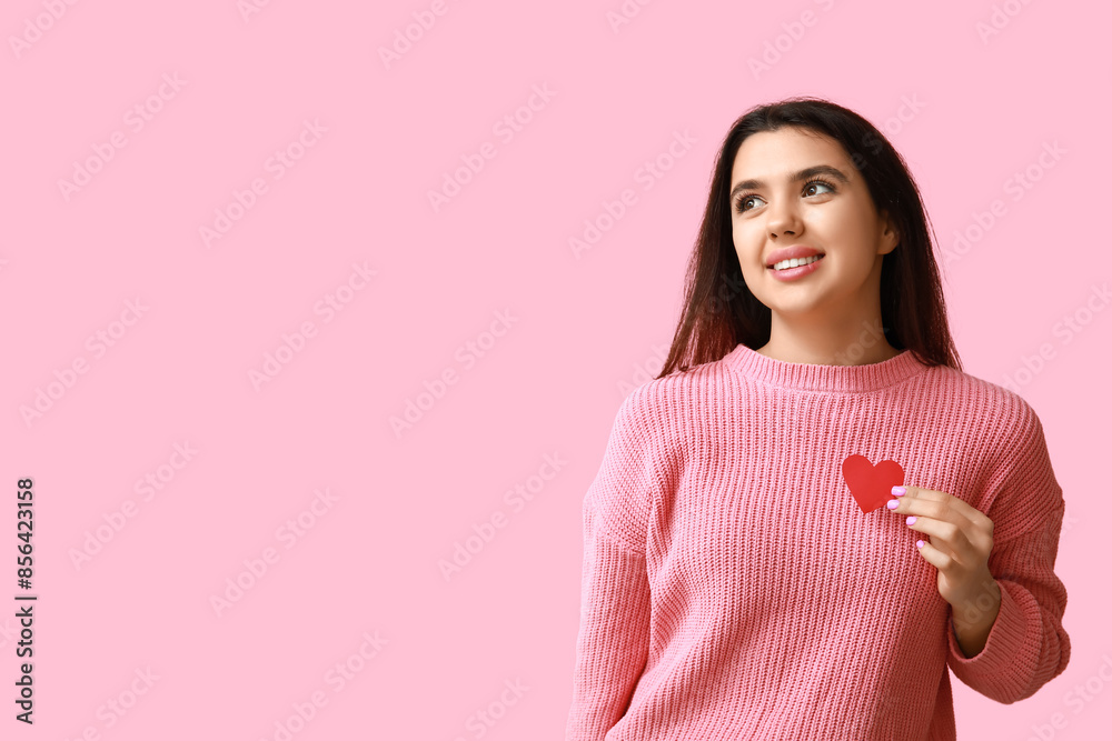 Beautiful young girl with red paper heart on pink background. Valentine's Day celebration Beautiful young girl with red paper heart on pink background. Valentine's Day celebration