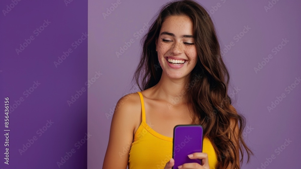 beautiful woman smiling at cell phone on purple background beautiful woman smiling at cell phone on purple background