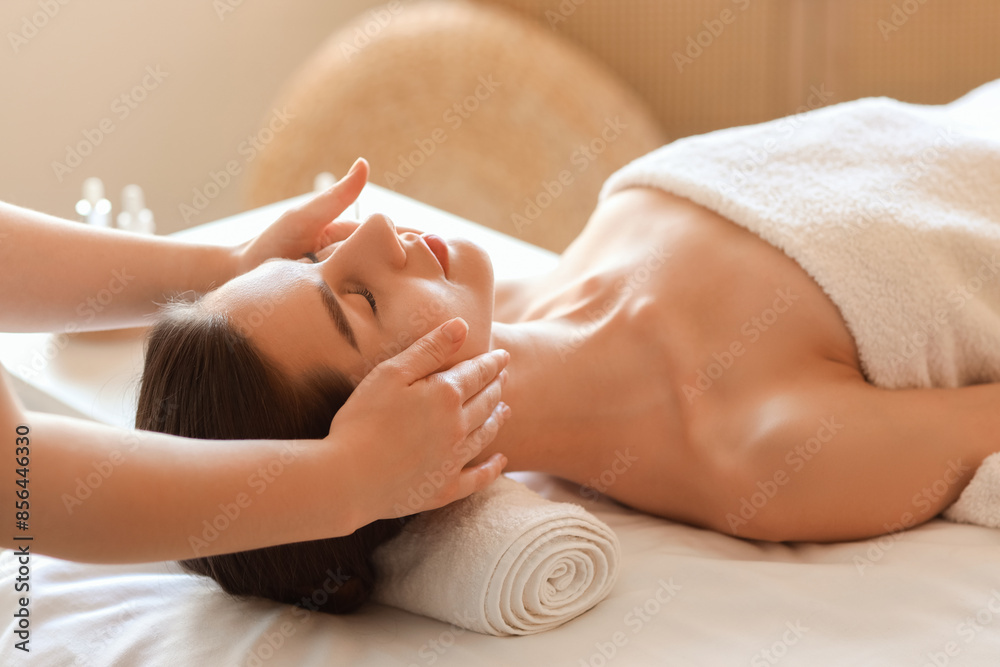 Obraz premium Young woman getting facial massage on couch in spa salon, closeup