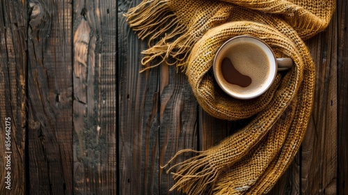 Coffee cup and old scarf on dark wood backdrop photo