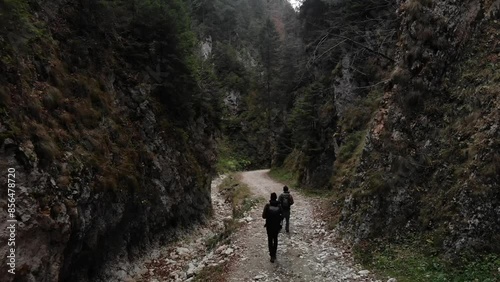 Romania, Romanian Carpathians - high rock walls of the Zarnesti Gorge and a wandering tourist photo