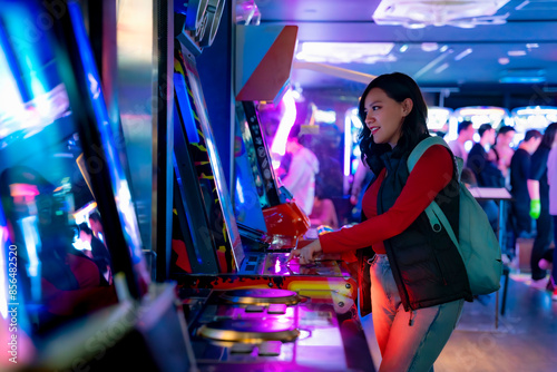 A young Latina woman smiling while playing arcade games in Akihabara, Tokyo, Japan, with glowing futuristic screens.