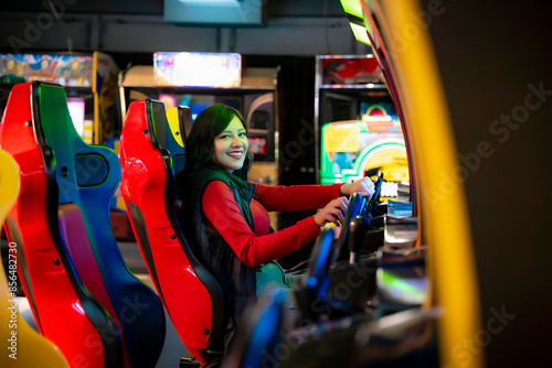 Photos Young Latina woman smiling and playing arcade games in Akihabara, Tokyo, Japan, surrounded by colorful lights and machines