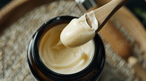 A close-up of a jar of night cream with a small amount on a spatula photo