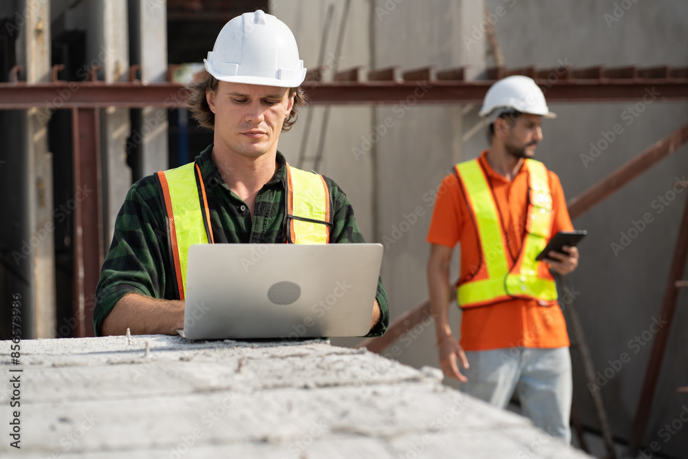 Portrait happy caucasian engineer man use notebook computer working with Hispanic Latin engineer man at precast cement outdoor factory Portrait happy caucasian engineer man use notebook computer working with Hispanic Latin engineer man at precast cement outdoor factory