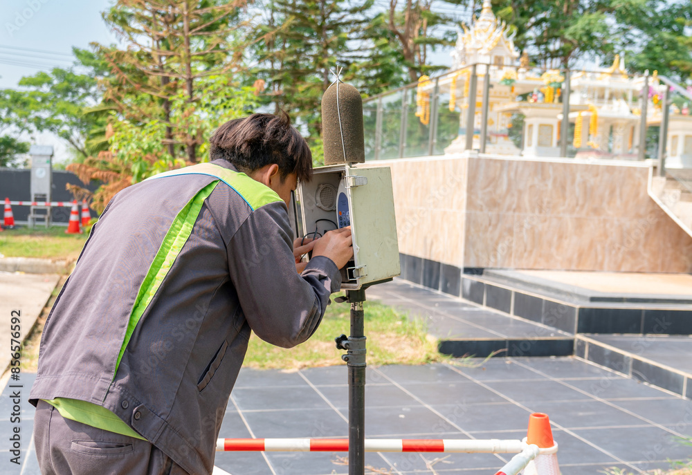Environment officer setting sound level meter for measurement sound level.