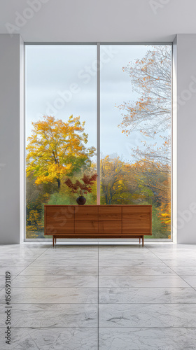 Stylish sideboard in a luxury apartment next to a window filling the room with natural lighting. Residential interior design composition for Real Estate with copy space.