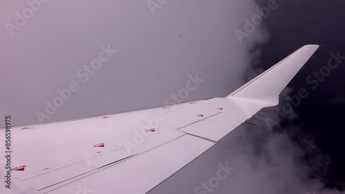 Airliner - pov scene of white wing passing through cloud cover - right after take off - close uf of winglet fin at the end of the airliner wing photo