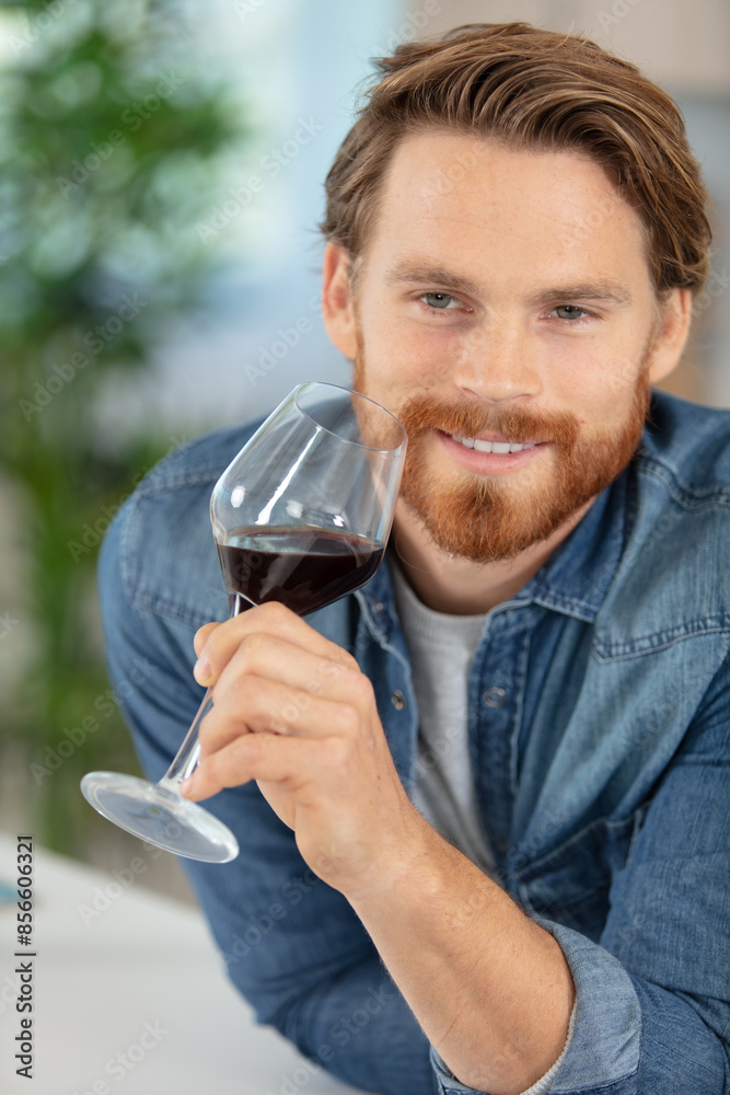 handsome young man smelling red wine before drinking it handsome young man smelling red wine before drinking it