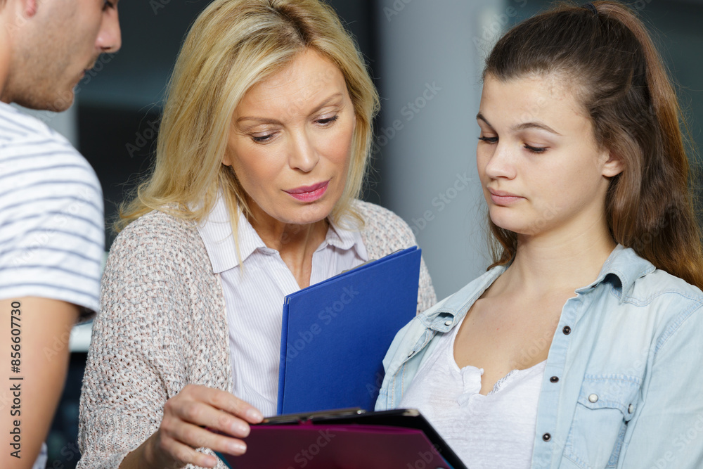 mature female teacher helping teenage student mature female teacher helping teenage student