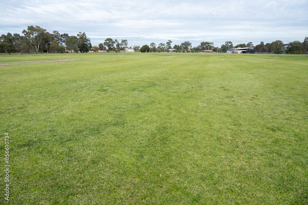 Background texture of a large grass lawn in a public sports ground in a local urban park of a suburb in Australia. Vacant land with copy space for design.Cambridge reserve, Hoppers Crossing, Melbourne Background texture of a large grass lawn in a public sports ground in a local urban park of a suburb in Australia. Vacant land with copy space for design.Cambridge reserve, Hoppers Crossing, Melbourne