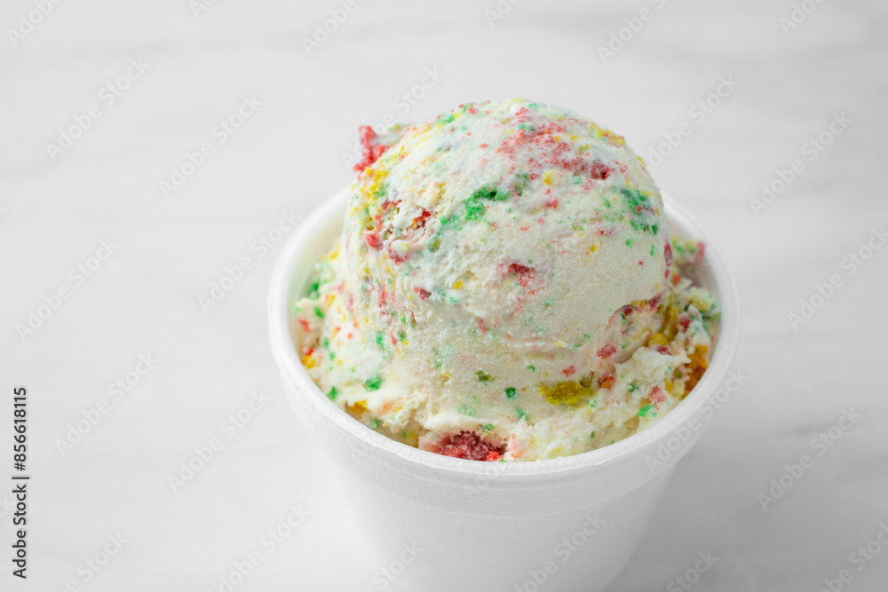 A view of one small scoop of birthday cake ice cream in a styrofoam cup. A view of one small scoop of birthday cake ice cream in a styrofoam cup.
