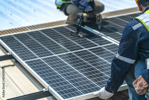 Worker Technicians are working to construct solar panels system on roof with sky and clound on background. Installing solar photovoltaic panel system. Renewable clean energy technology concept.